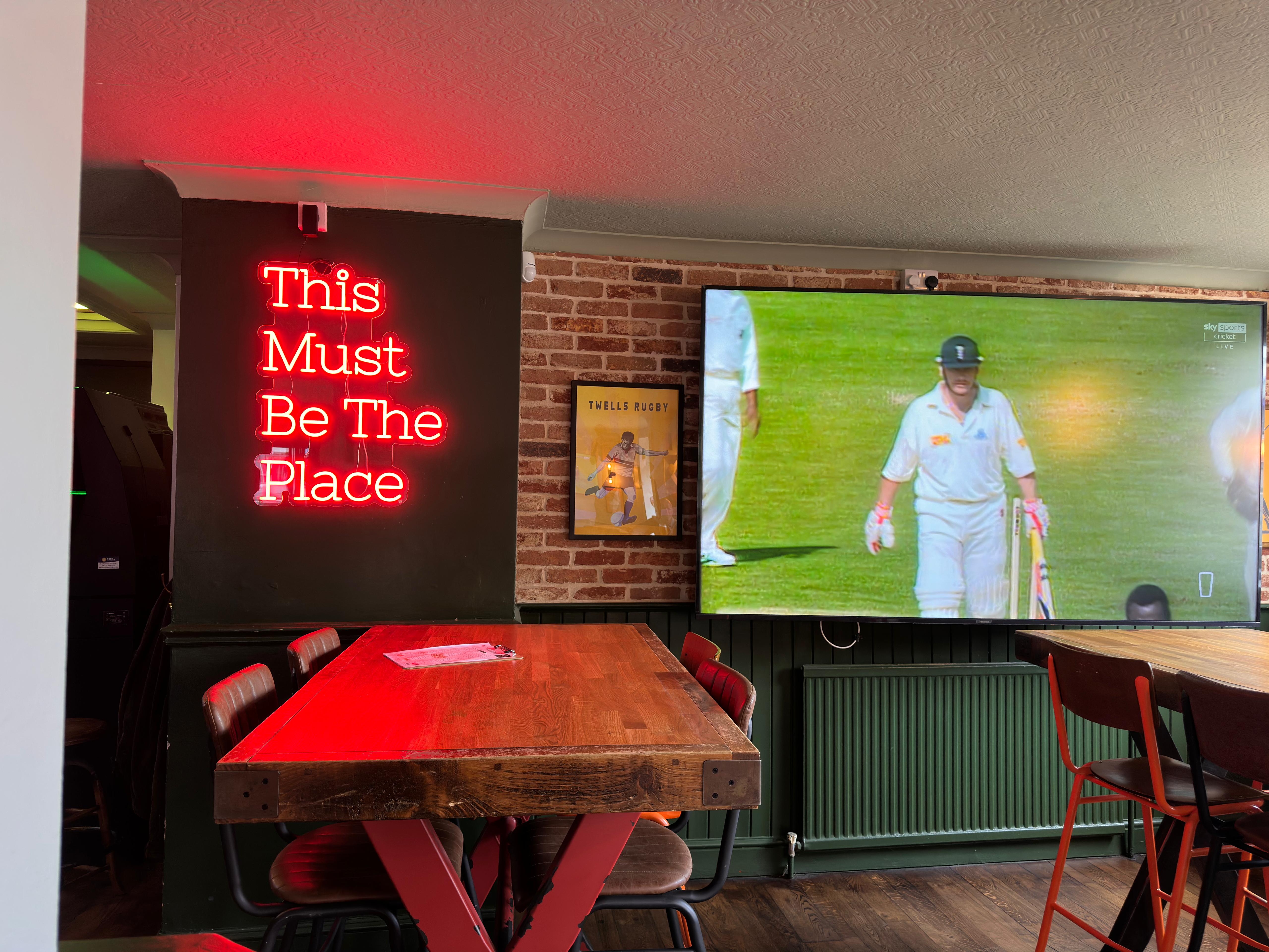 Neon Sports Table under the This Must Be The Place sign